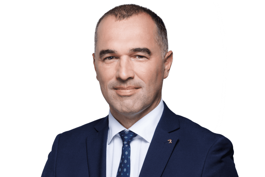 A man in a suit and tie with a green background.